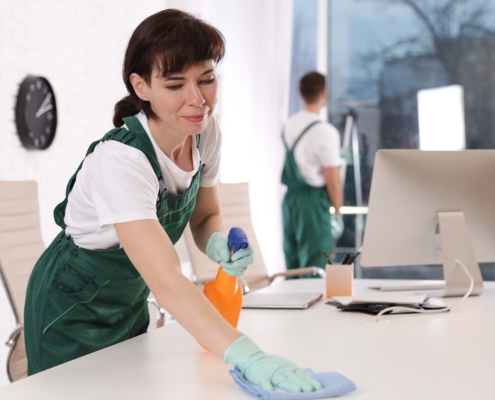 Janitor Wiping Down Office Desk