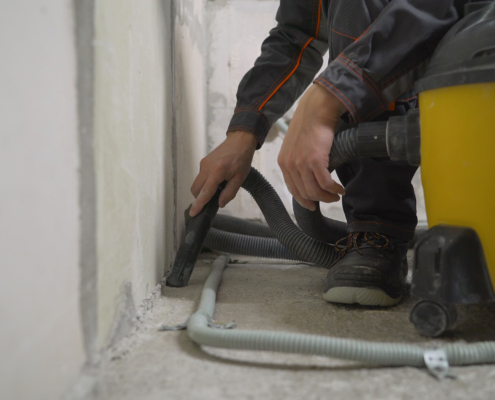 Worker Washes The Floor With A Vacuum Cleaner From Industrial Concrete Dust
