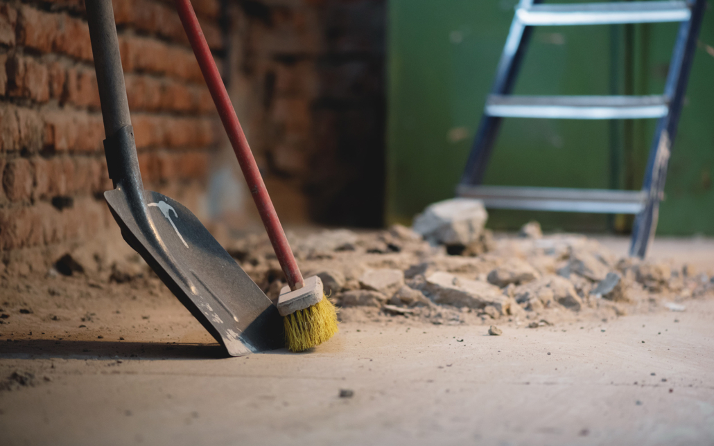 Shovel And Broom On The Dusty Construction Site Floor Background