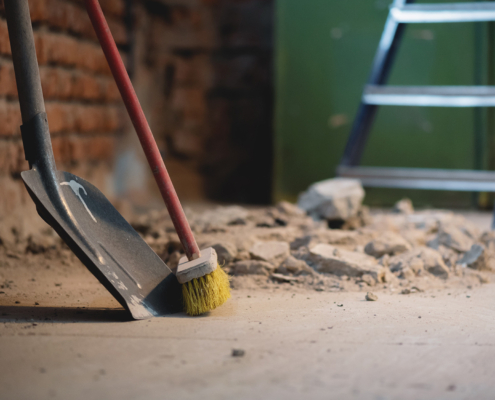 Shovel And Broom On The Dusty Construction Site Floor Background
