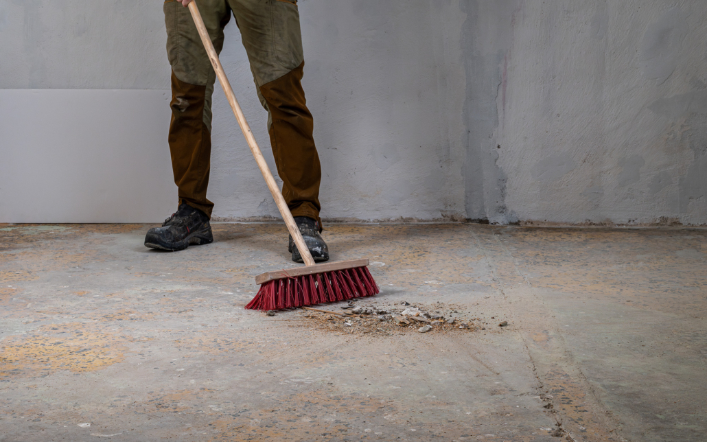 Worker Sweeping Debris During Renovation