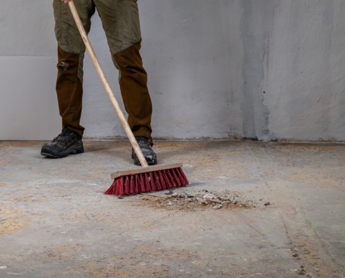 Worker Sweeping Debris During Renovation